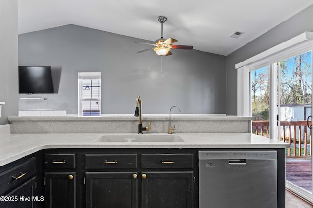 kitchen featuring visible vents, dishwasher, lofted ceiling, dark cabinetry, and a sink