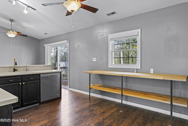 kitchen with visible vents, light countertops, stainless steel dishwasher, dark cabinetry, and a sink