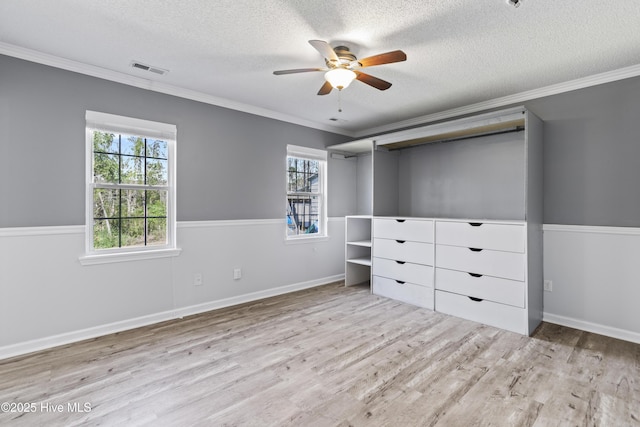 unfurnished bedroom with a textured ceiling, crown molding, and wood finished floors