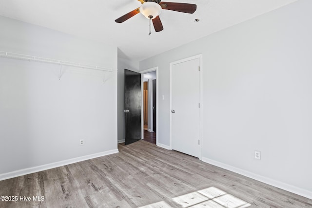 unfurnished bedroom featuring wood finished floors, baseboards, and ceiling fan