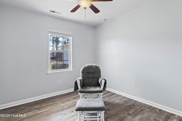 unfurnished room featuring ceiling fan, visible vents, baseboards, and wood finished floors