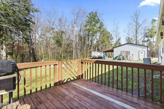 deck featuring an outdoor structure, a playground, and a lawn