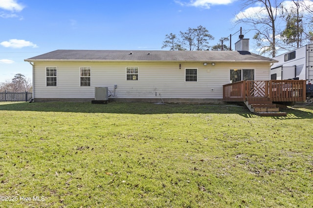 rear view of house with a deck, a yard, central AC, and a chimney