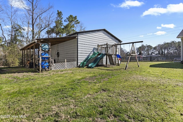 view of outdoor structure featuring a playground and fence