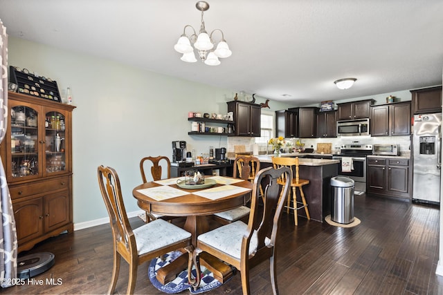 dining area featuring an inviting chandelier, baseboards, and dark wood-style flooring