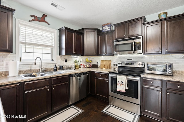 kitchen with a sink, dark brown cabinetry, a toaster, and stainless steel appliances