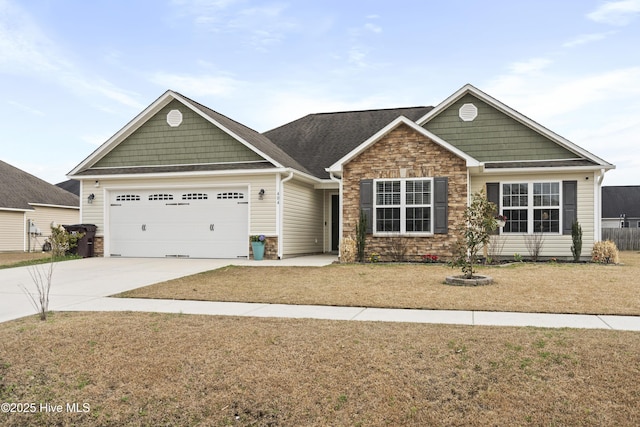 craftsman house with stone siding, a front lawn, concrete driveway, and a garage