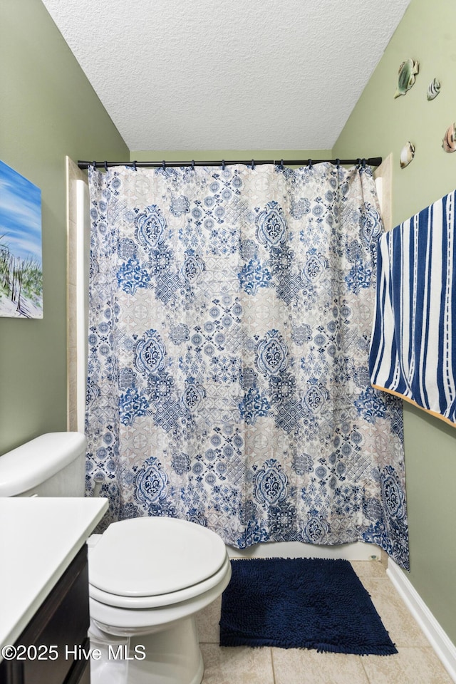 full bath featuring vanity, tile patterned floors, toilet, and a textured ceiling