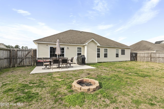 back of property featuring a yard, a shingled roof, a fenced backyard, and a patio area