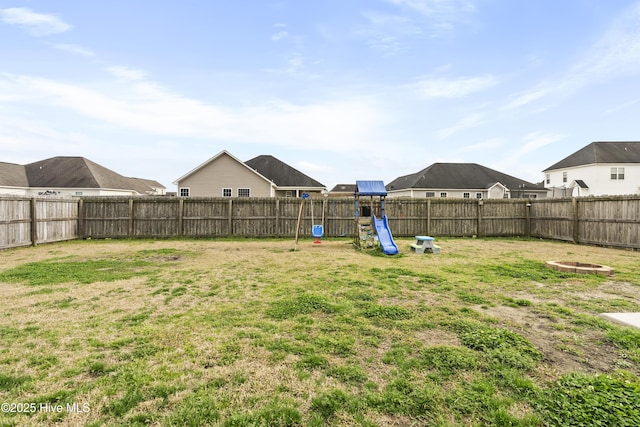 view of yard featuring a playground and a fenced backyard
