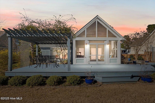 back of property at dusk featuring a pergola and a wooden deck