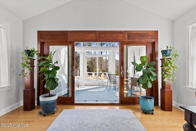 foyer featuring vaulted ceiling, wood finished floors, and french doors