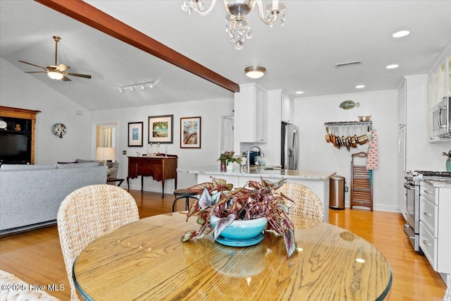 dining room with ceiling fan with notable chandelier, light wood-style flooring, vaulted ceiling with beams, and visible vents