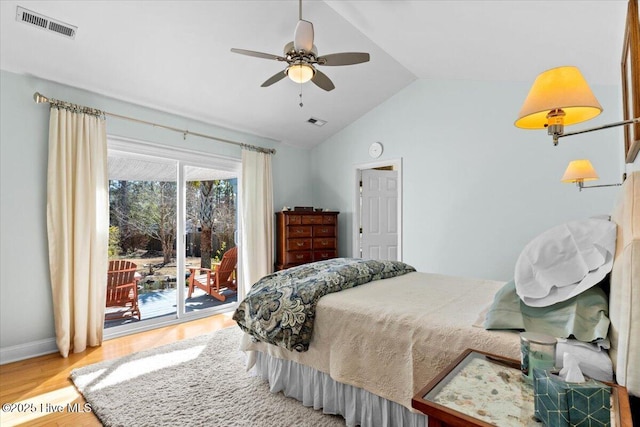 bedroom with visible vents, wood finished floors, vaulted ceiling, and access to outside