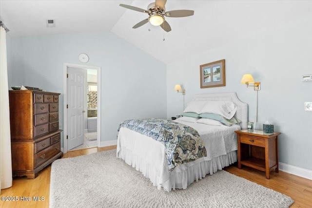 bedroom with visible vents, baseboards, light wood-style floors, and vaulted ceiling