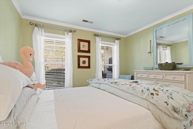 bedroom featuring visible vents, multiple windows, and crown molding