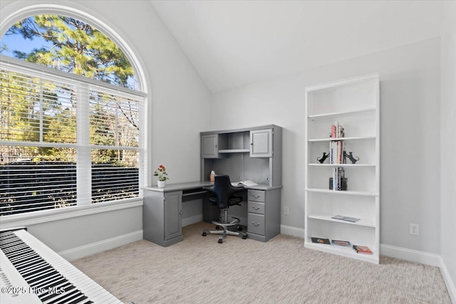 office area with light carpet, baseboards, and vaulted ceiling