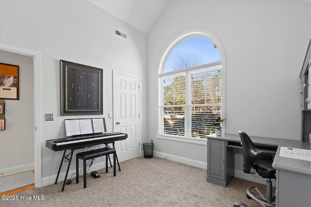 office space featuring lofted ceiling, light colored carpet, visible vents, and baseboards