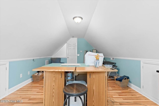 bar featuring lofted ceiling, light wood-style floors, and baseboards