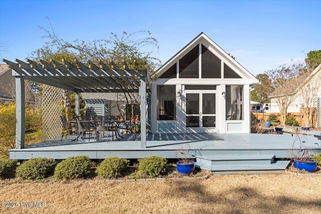 rear view of property featuring a wooden deck, a pergola, and a sunroom