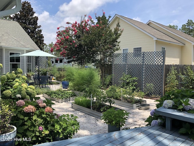 wooden terrace featuring a vegetable garden and fence