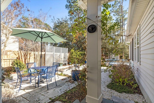 view of patio with outdoor dining space and fence