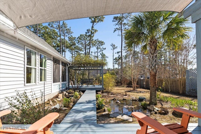 view of yard featuring a deck, a pergola, and fence