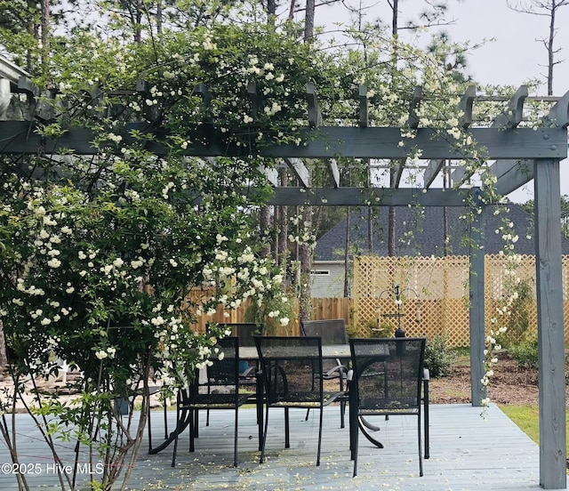 view of patio featuring a pergola, outdoor dining area, and fence