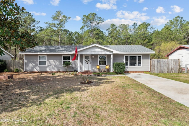 ranch-style home featuring a front lawn and fence