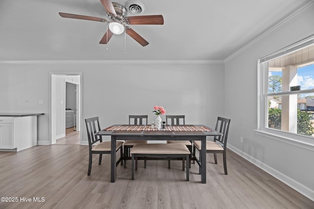 dining area featuring visible vents, light wood-type flooring, and crown molding