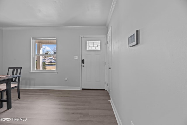 foyer featuring crown molding, baseboards, and wood finished floors