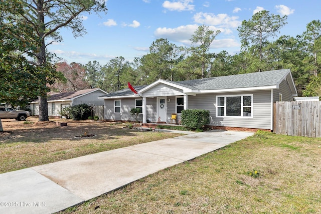 ranch-style home featuring a porch, roof with shingles, a front lawn, and fence