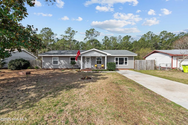 ranch-style house featuring driveway, a front yard, and fence