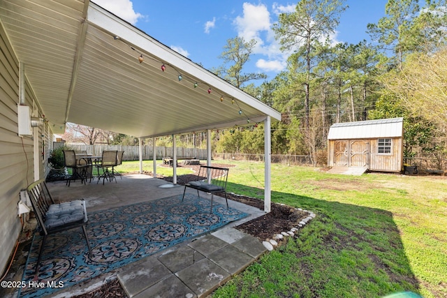 view of yard featuring a patio, a storage unit, a fenced backyard, and an outdoor structure