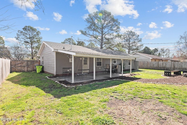 back of property featuring a patio, a yard, and a fenced backyard