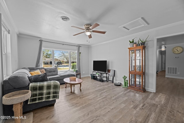 living room with visible vents, attic access, and ornamental molding