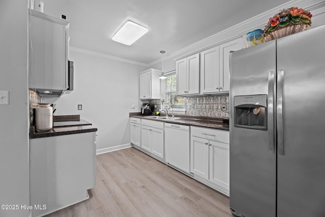 kitchen with dark countertops, crown molding, decorative backsplash, stainless steel refrigerator with ice dispenser, and white dishwasher