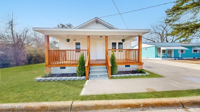 bungalow-style home with a front yard, covered porch, and crawl space