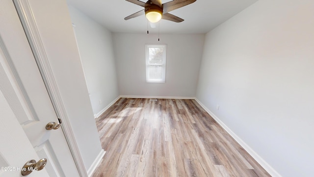 spare room featuring ceiling fan, baseboards, and light wood-style flooring