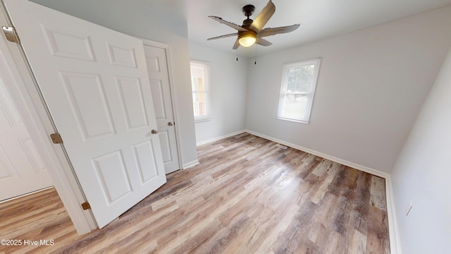 unfurnished bedroom featuring a ceiling fan, light wood-style floors, and baseboards