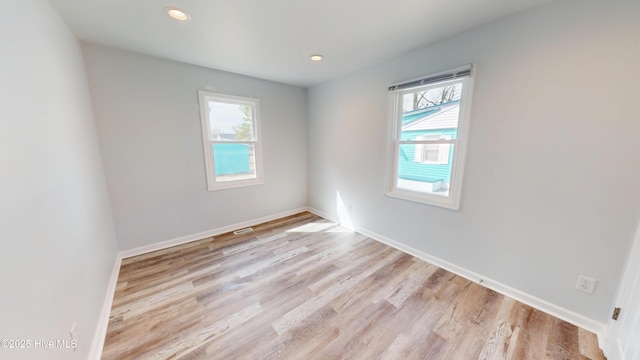 spare room featuring recessed lighting, a healthy amount of sunlight, and light wood-type flooring