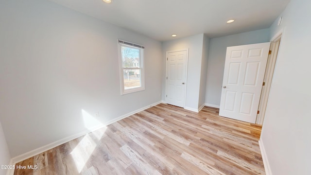 unfurnished bedroom with recessed lighting, baseboards, and light wood-style flooring