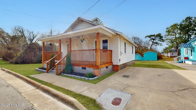 bungalow featuring crawl space, covered porch, driveway, and a front lawn