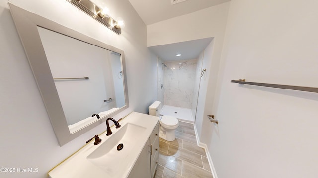 full bathroom featuring baseboards, toilet, a stall shower, and vanity