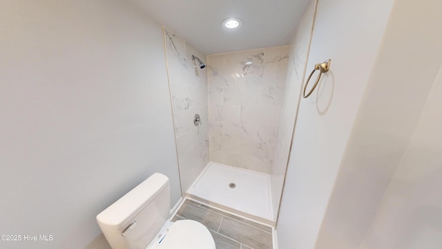 bathroom with a shower stall and toilet