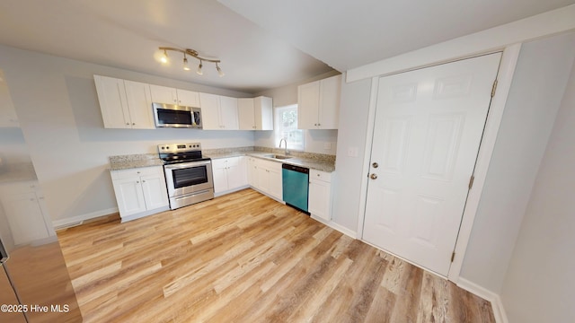 kitchen with white cabinets, stainless steel appliances, light wood-type flooring, and a sink