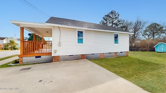 view of property exterior featuring crawl space, a patio area, a lawn, and roof with shingles