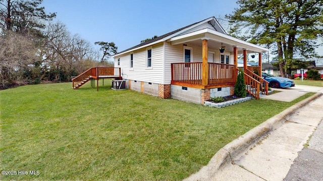 view of side of property featuring central air condition unit, stairway, a lawn, covered porch, and crawl space