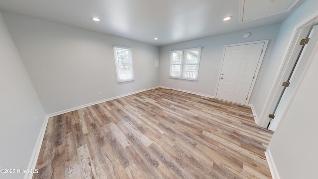 spare room with attic access, recessed lighting, light wood-style floors, and baseboards