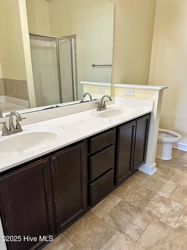 bathroom with double vanity, a sink, toilet, and a shower stall